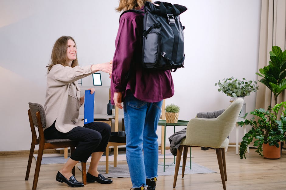 A therapist extends a handshake to welcome a new client in a cozy office setting.