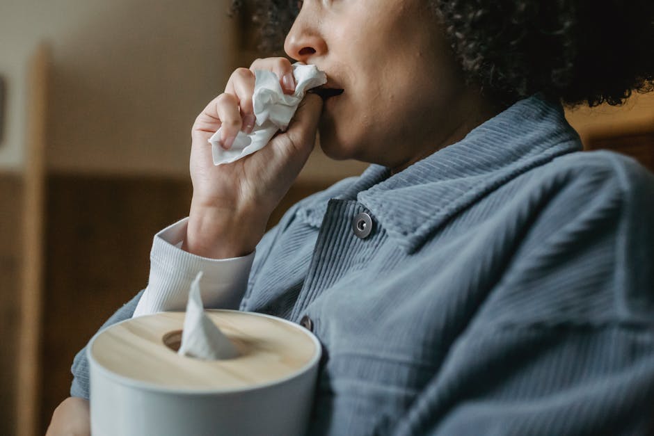 Close-up of a woman holding tissues, expressing sadness indoors.